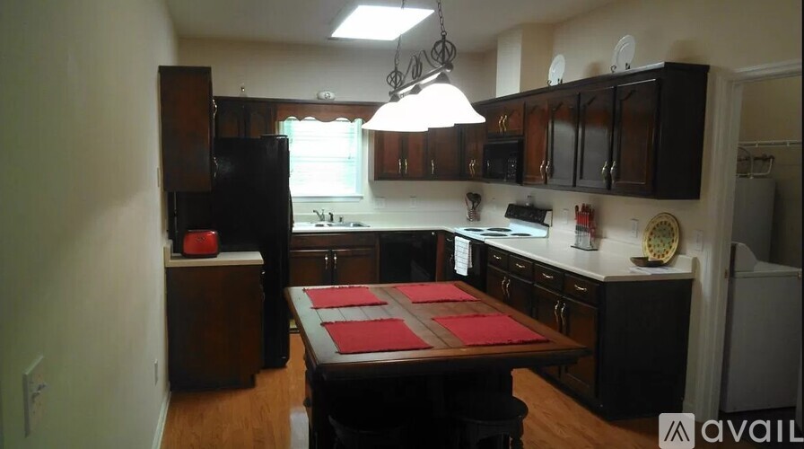 A kitchen with a table and chairs in the middle.