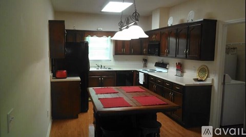 A kitchen with a table and chairs in the middle.