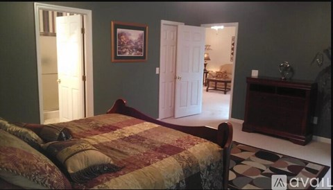 A bedroom with a bed, dresser, and mirror.