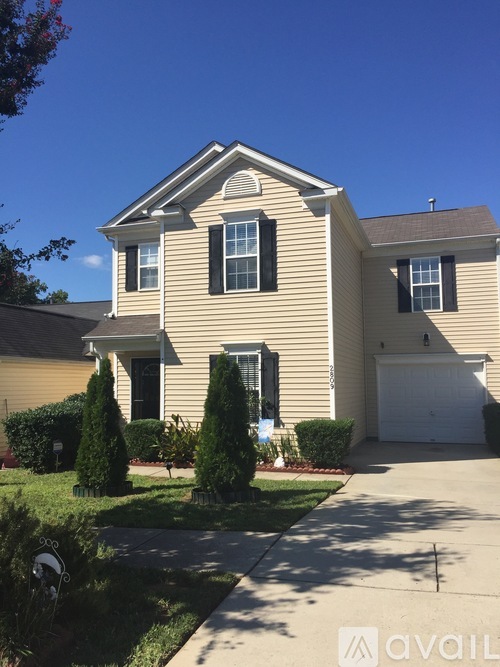 A two-story house with a garage and a driveway.