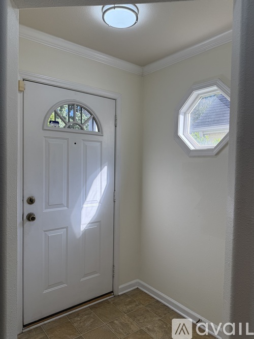 A white door with a window above it in a room.