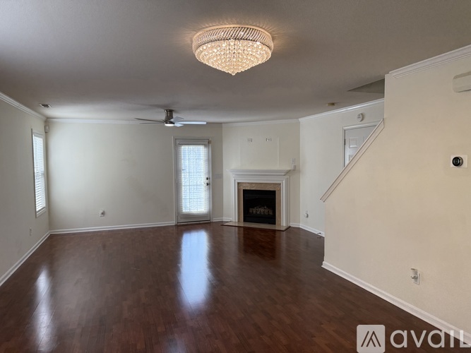 A spacious room with wood flooring and a ceiling fan.