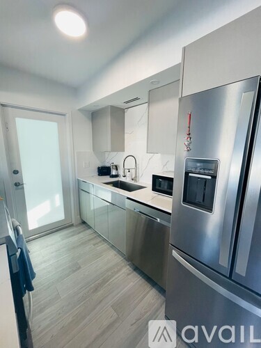 A modern kitchen with a stainless steel refrigerator and a black oven.
