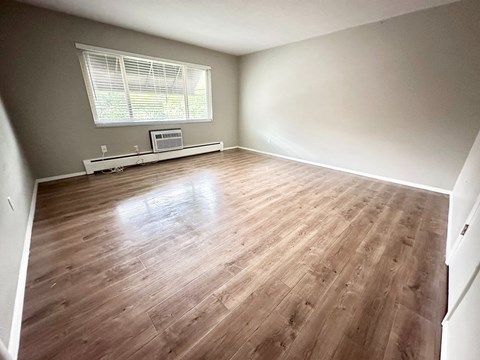 A room with wooden flooring and a window.