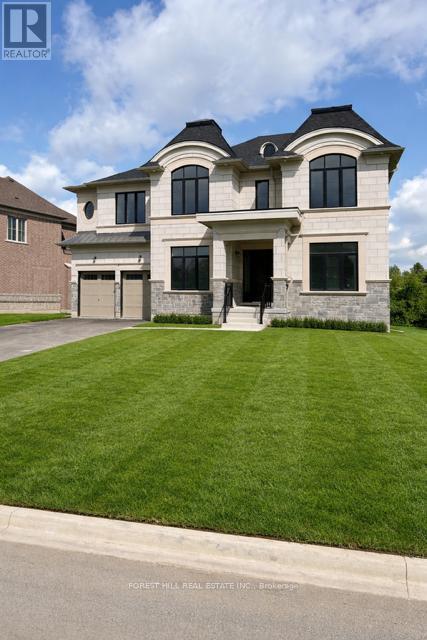 A large, two-story house with a garage is situated on a well-manicured lawn.