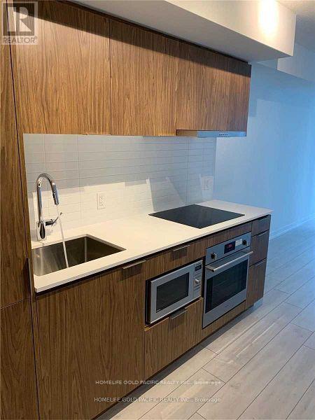 A modern kitchen with wooden cabinets and stainless steel appliances.
