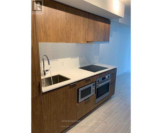 A modern kitchen with wooden cabinets and stainless steel appliances.