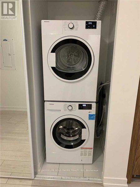 Two white front loading washing machines in a small space.