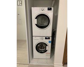 Two white front loading washing machines in a small space.