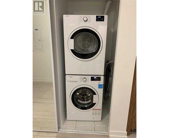 Two white front loading washing machines in a small space.