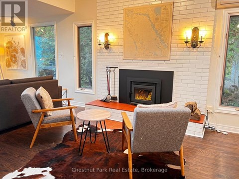 A living room with a fireplace and a painting on the wall.