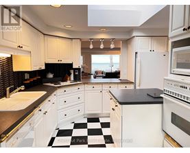 A kitchen with white cabinets and a black and white checkered floor.
