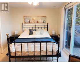 A bedroom with a black metal bed frame and a white bedspread.