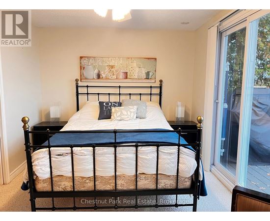 A bedroom with a black metal bed frame and a white bedspread.