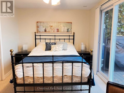 A bedroom with a black metal bed frame and a white bedspread.
