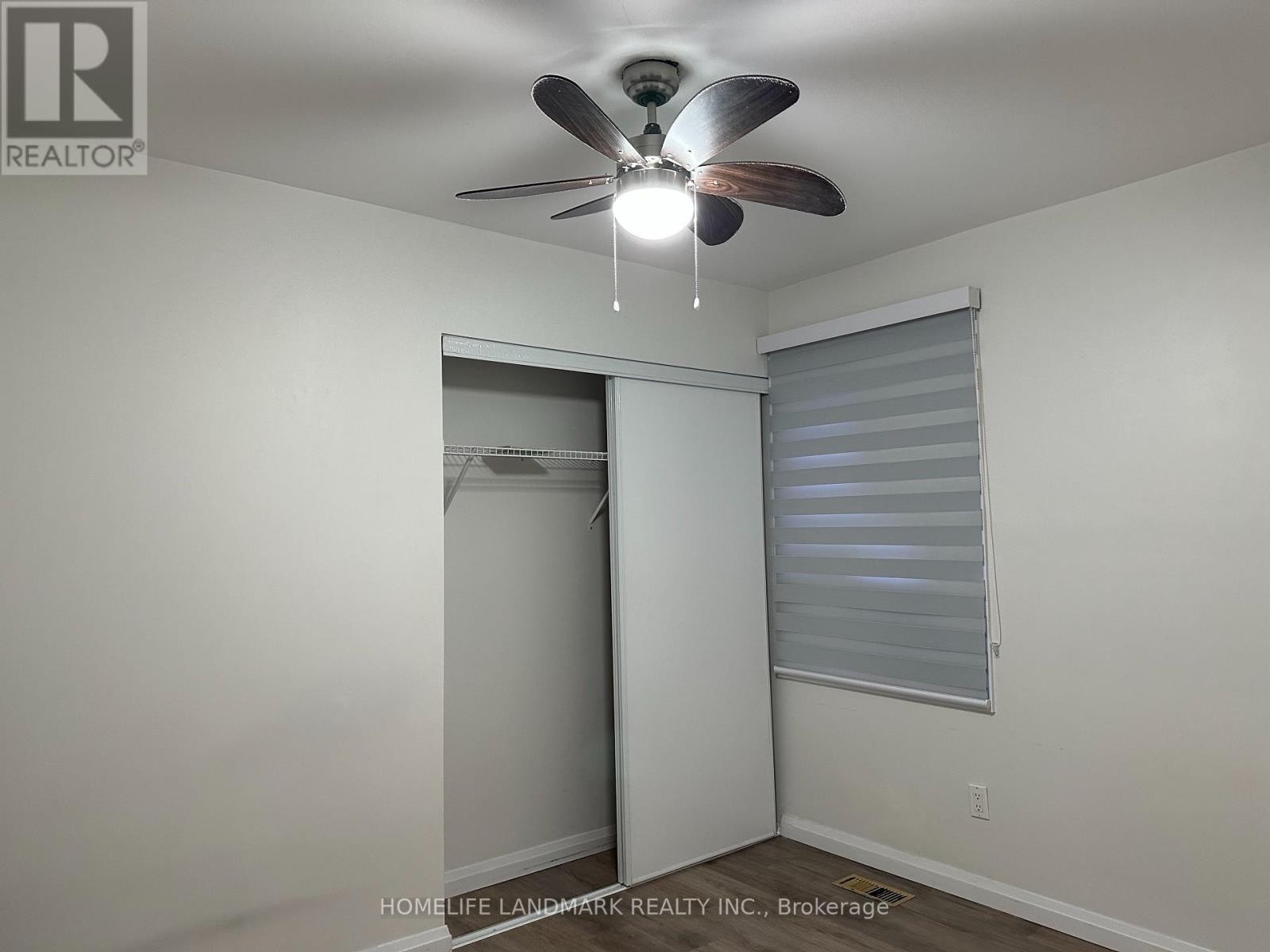 A room with a ceiling fan and a closet.