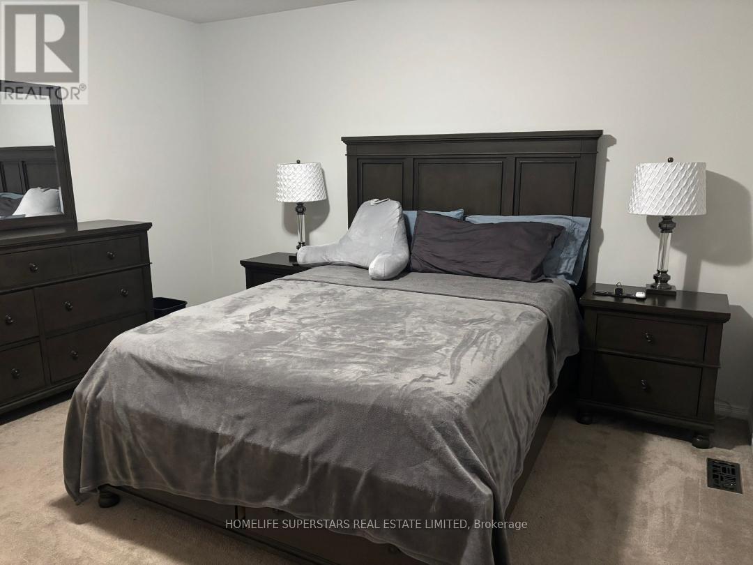 A bedroom with a bed, nightstands, and lamps.