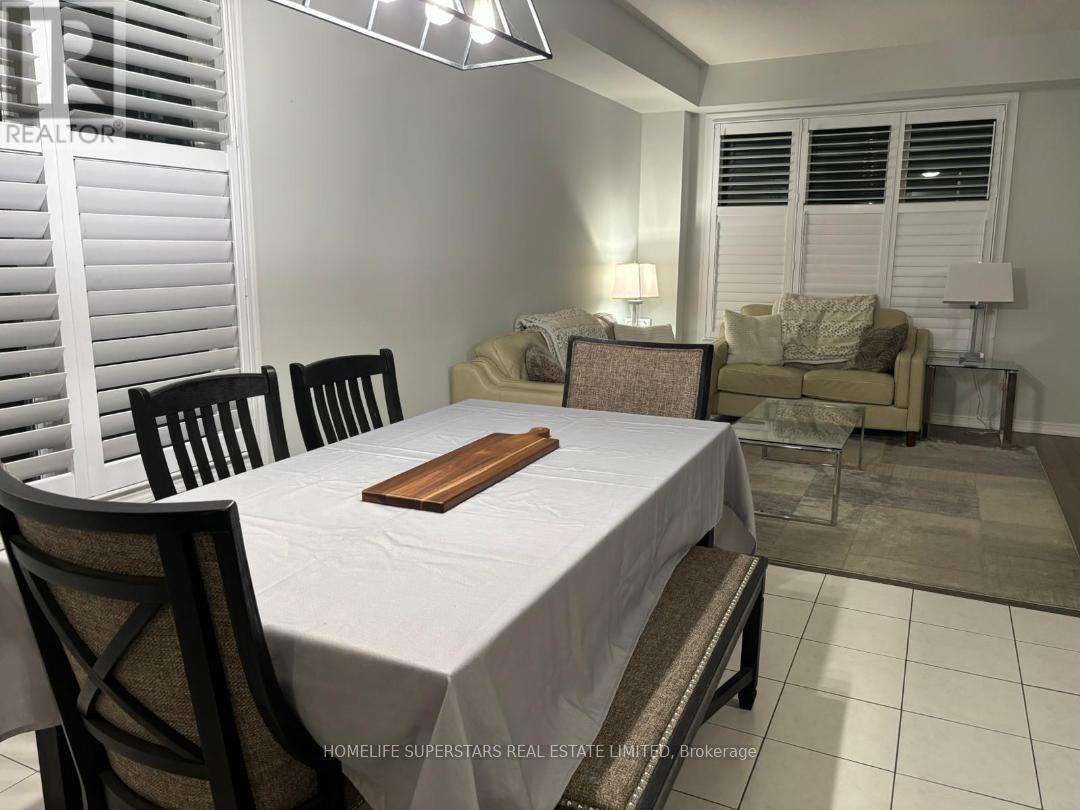 A dining room with a white table and chairs.
