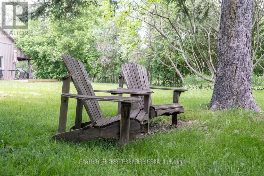 A wooden chair and bench are placed in a grassy area.