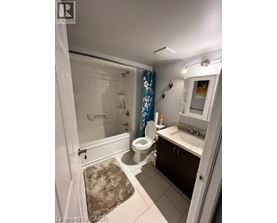 A bathroom with a toilet, sink, and shower.