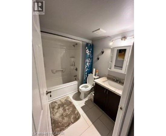 A bathroom with a toilet, sink, and shower.