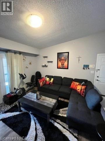 A black couch with a red pillow is in the center of the room.