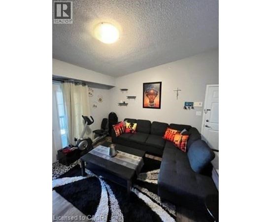 A black couch with a red pillow is in the center of the room.
