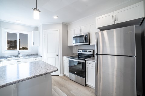 A modern kitchen with stainless steel appliances and white cabinetry.