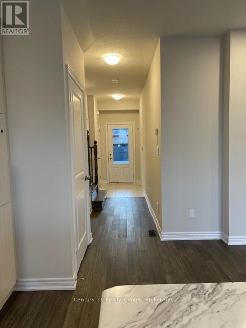 A hallway with wood floors and white walls.
