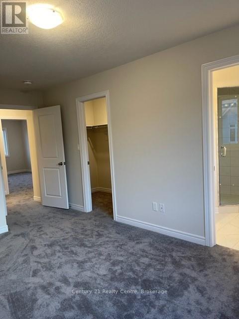 A room with a carpeted floor and a doorway leading to another room.