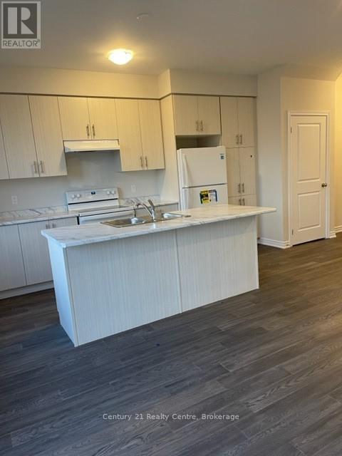 A kitchen with white cabinets and a white fridge.