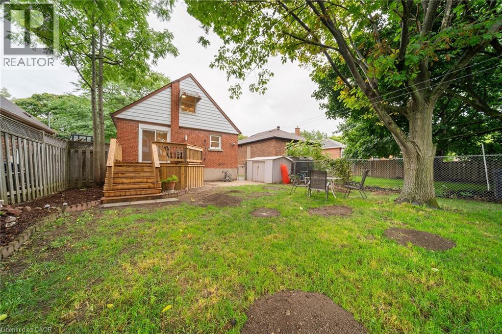 A house with a yard and a tree in front of it.