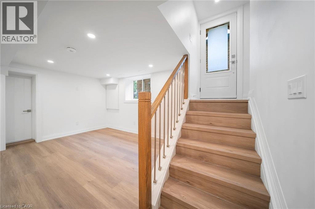A wooden staircase leads up to a white door.
