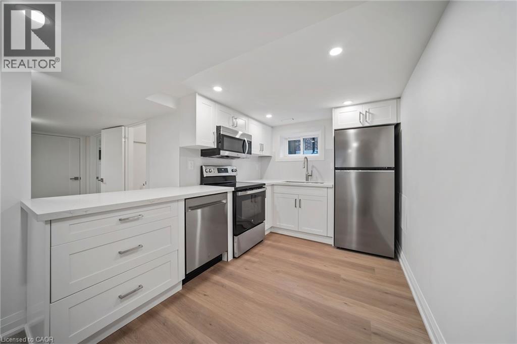 A modern kitchen with white cabinets and stainless steel appliances.