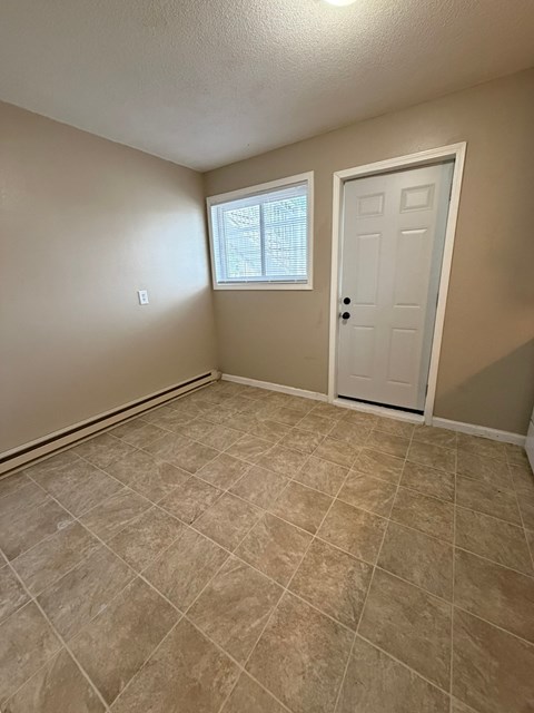 A room with a white door and a window with blinds.