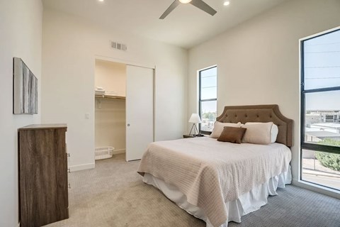 A bedroom with a large bed and a ceiling fan.