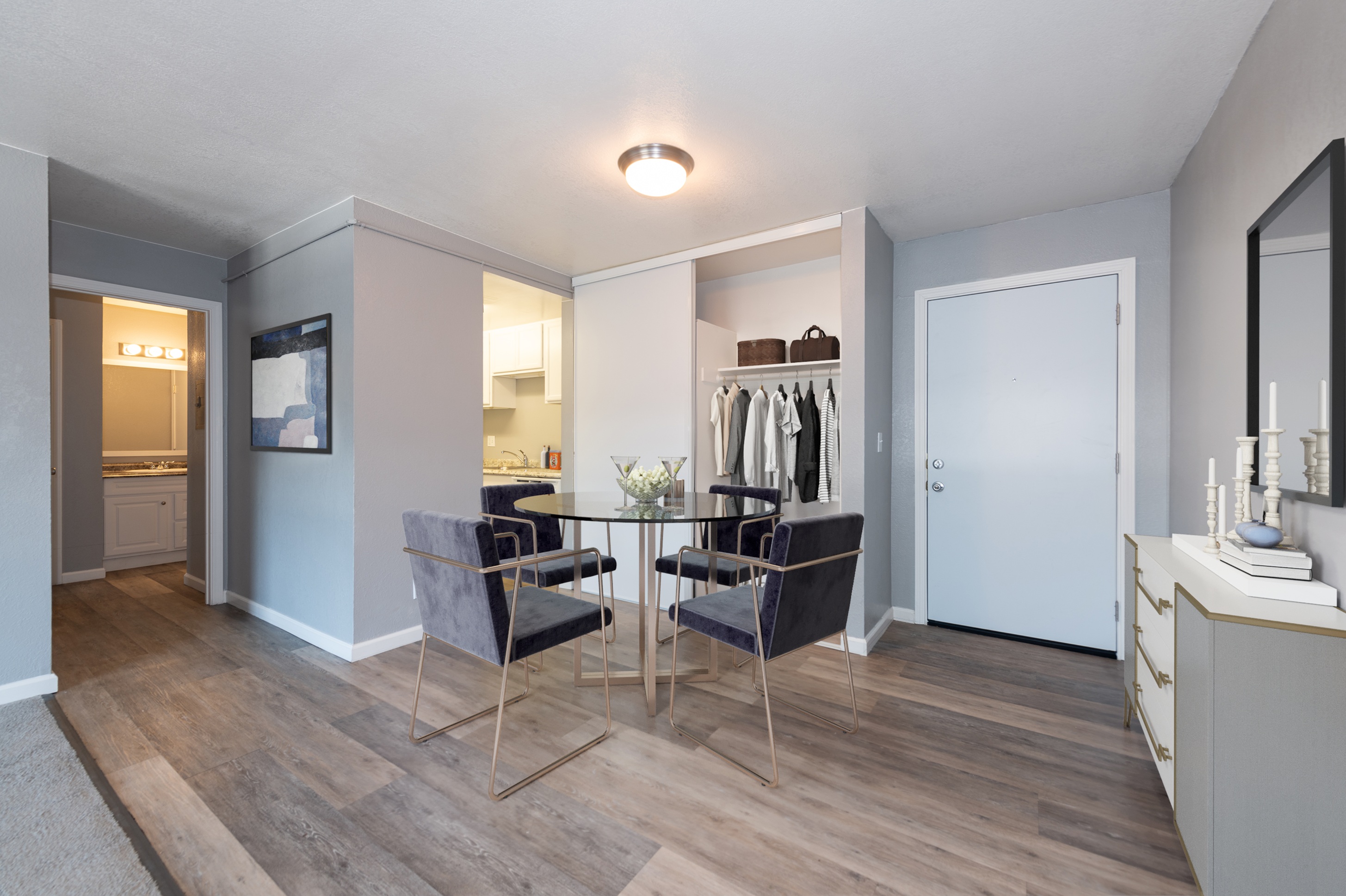 A room with a grey sofa and a wooden floor.