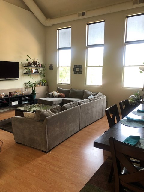 A living room with a grey couch and a wooden table.