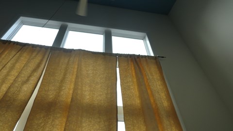 A window with a curtain is open.