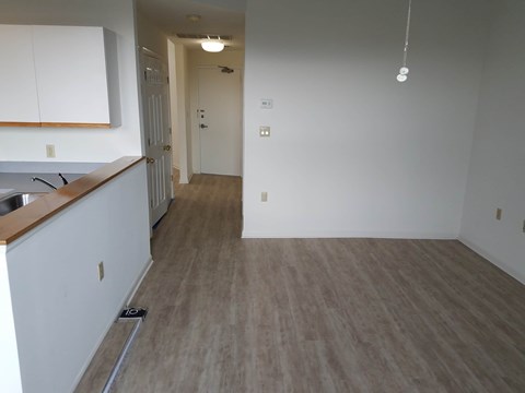 A kitchen with white cabinets and a wooden counter top.
