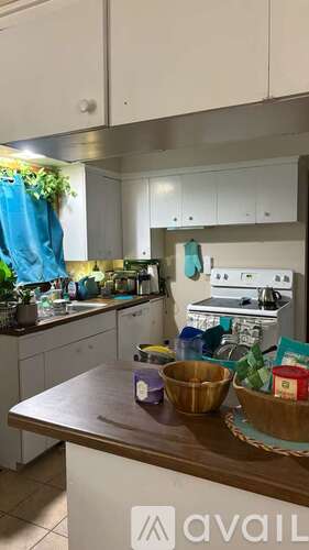 A kitchen with a wooden countertop and white cabinets.
