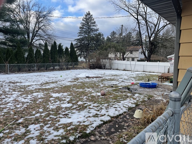 A backyard with a fence and a blue pool.