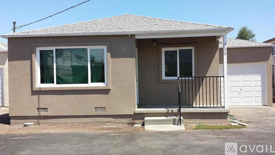 A house with a beige exterior and a white garage door.