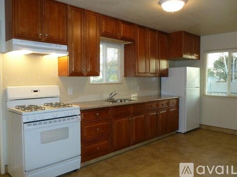A kitchen with wooden cabinets and a white stove.