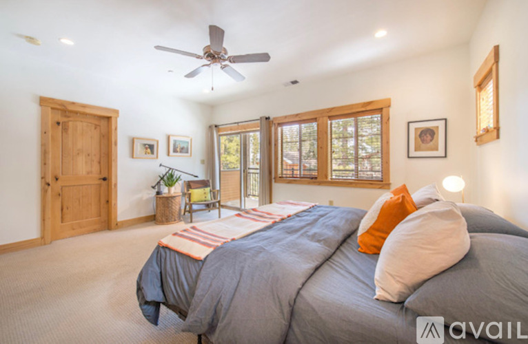 A bedroom with a large bed and a ceiling fan.