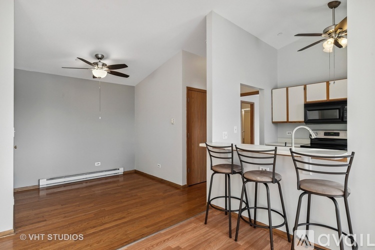 A kitchen with a bar stool and a ceiling fan.