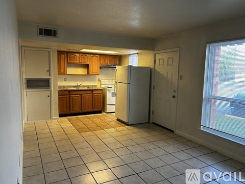 A kitchen with white appliances and wooden cabinets.