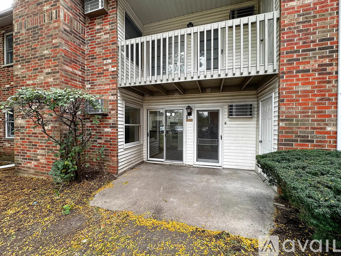 A balcony with a white railing and a glass door.