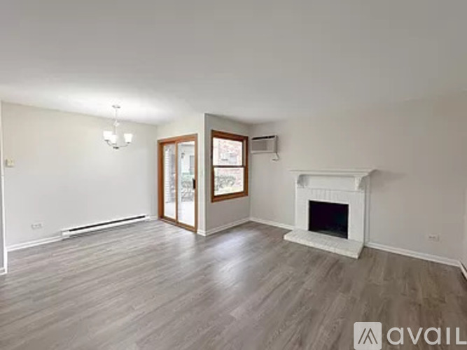 A spacious living room with a fireplace and hardwood flooring.