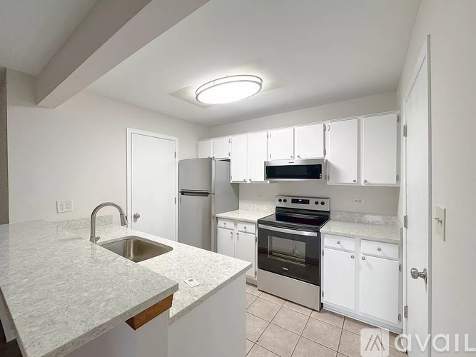 A kitchen with white cabinets and a marble countertop.